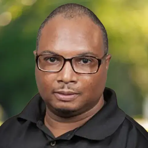 A professional headshot of a man wearing glasses.