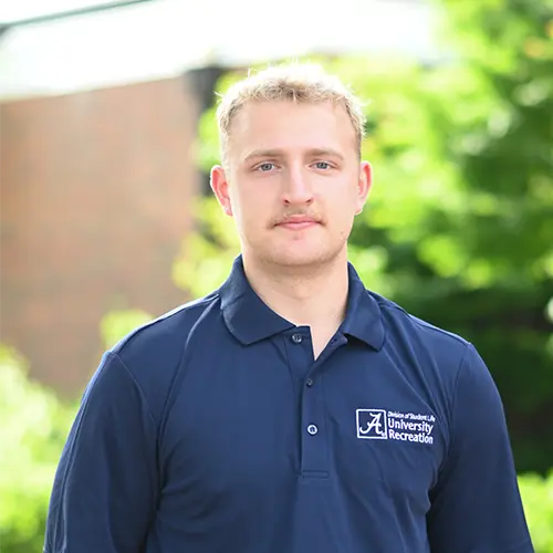 Smiling young man with blond hair wearing a navy blue